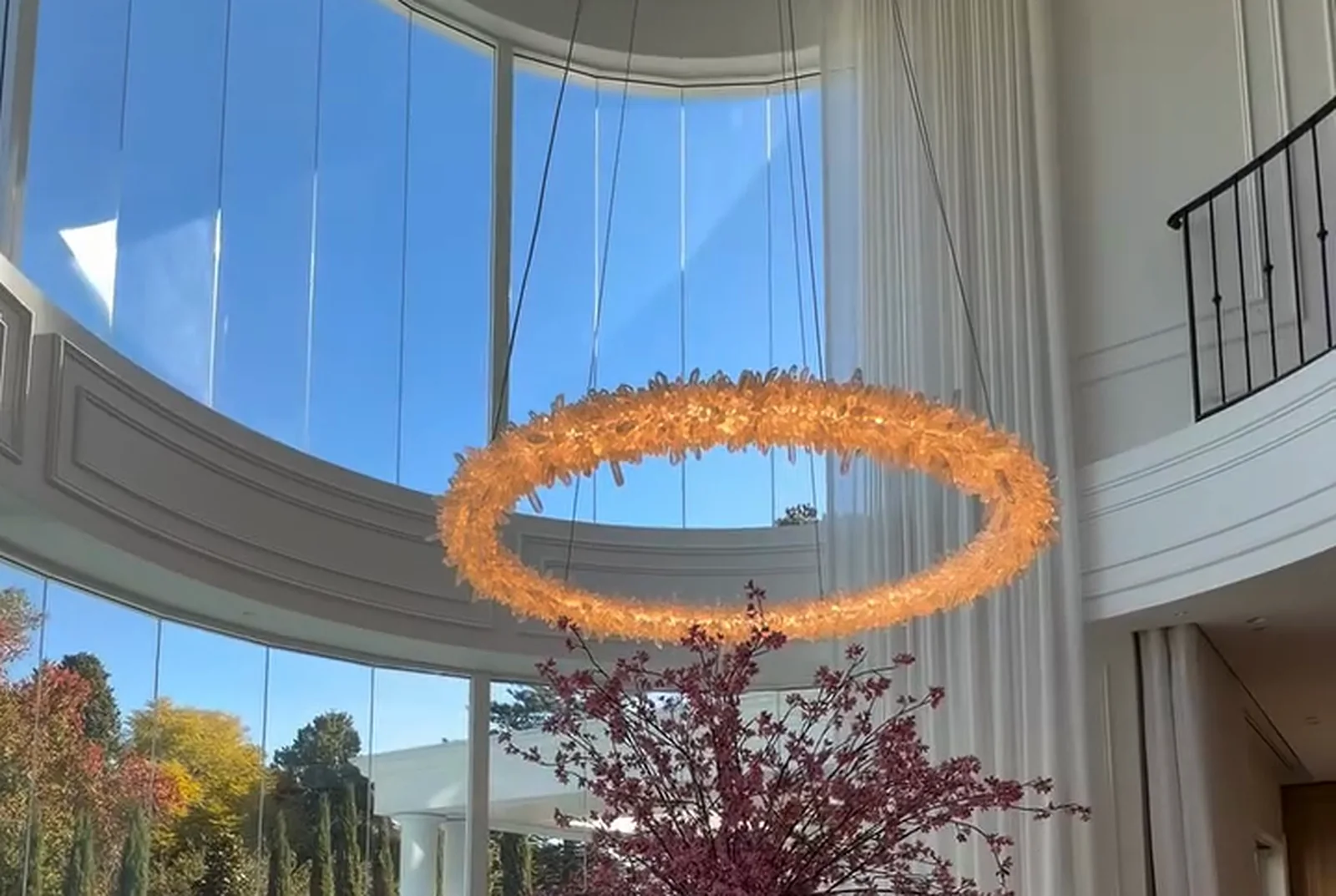 Double-height rotunda with a ring chandelier and curved glazing to the pool