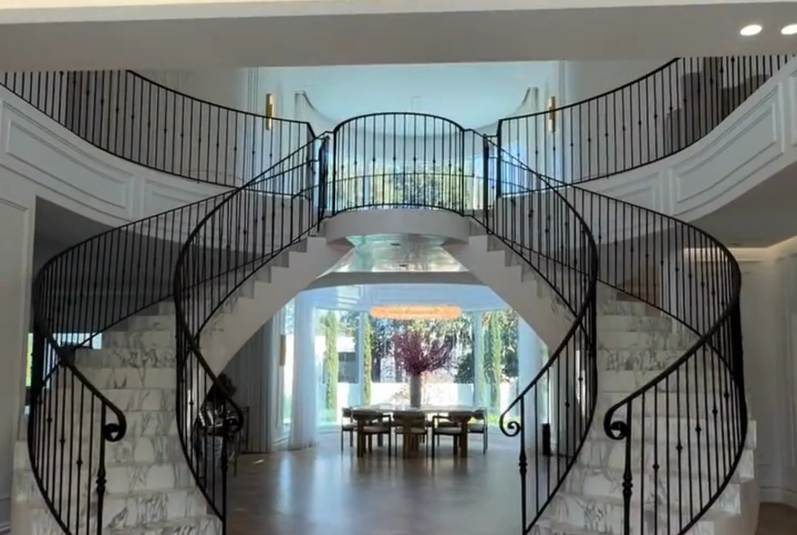 Entry hall with twin curved staircases in marble and wrought iron